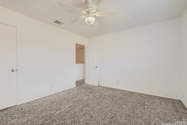 empty room featuring ceiling fan, carpet floors, and a textured ceiling