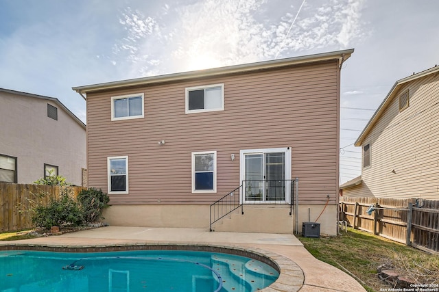 back of property featuring a fenced in pool