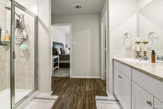 bathroom with vanity, hardwood / wood-style flooring, and a shower with shower door