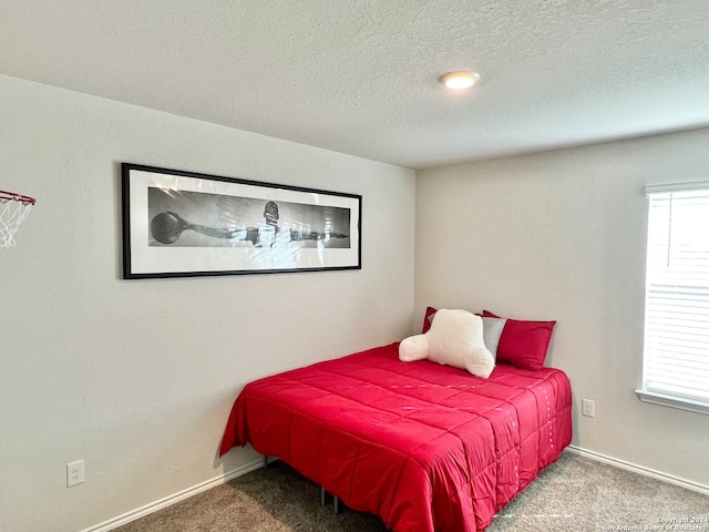 bedroom with carpet floors and a textured ceiling