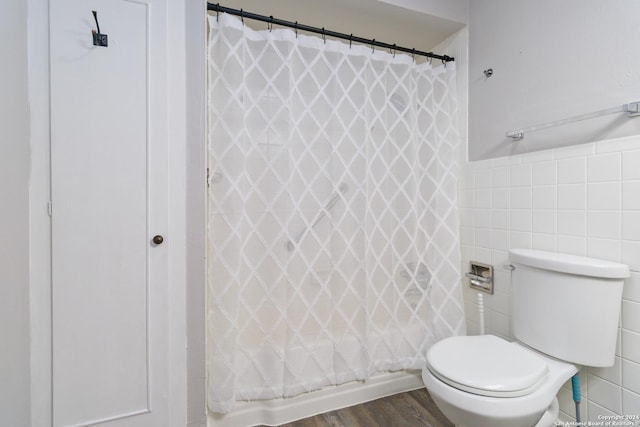 8038 Broadway Unit 225L, San Antonio, TX 78209 - full bathroom featuring toilet, curtained shower, tile walls, and wood finished floors