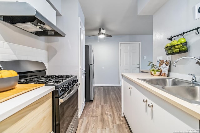8038 Broadway Unit 225L, San Antonio, TX 78209 - kitchen featuring gas range, ventilation hood, light wood-style floors, light countertops, and a ceiling fan