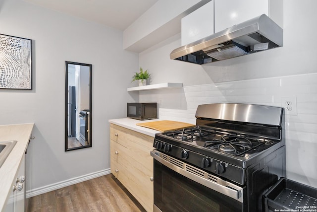 8038 Broadway Unit 225L, San Antonio, TX 78209 - kitchen featuring wood finished floors, exhaust hood, light countertops, backsplash, and black appliances