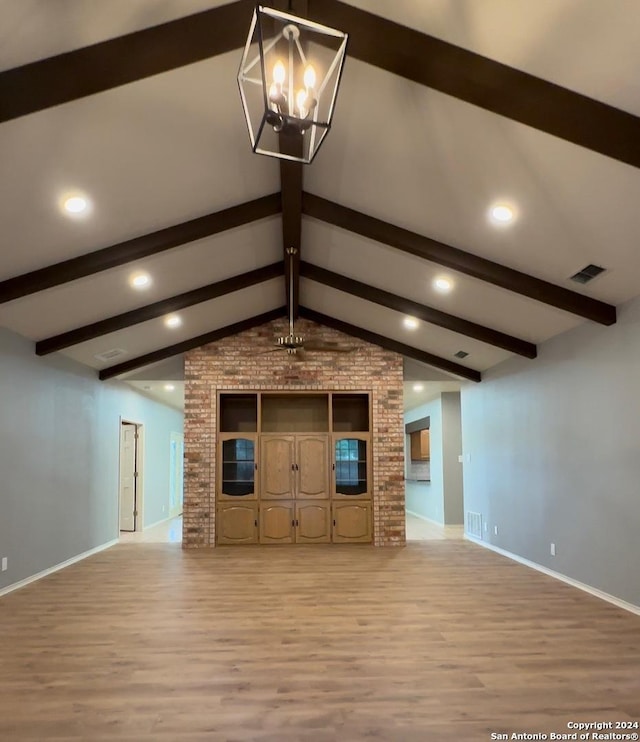 unfurnished living room with vaulted ceiling with beams, light wood-type flooring, and a chandelier