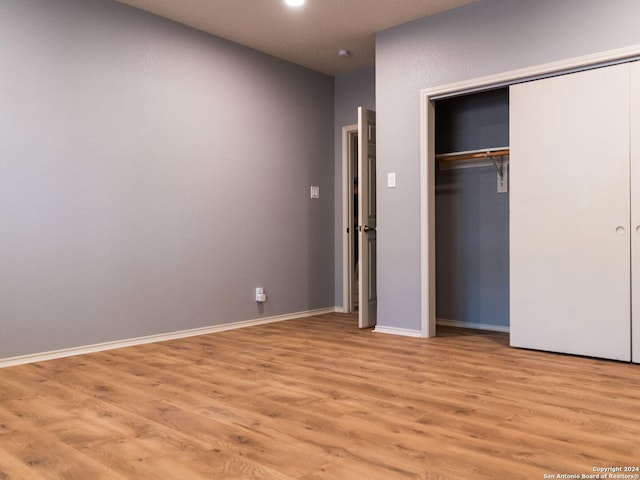 unfurnished bedroom featuring light hardwood / wood-style flooring and a closet