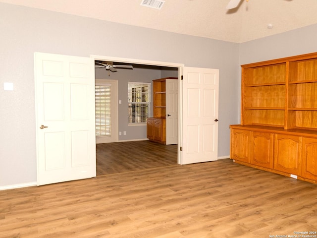 spare room with light wood-type flooring and a textured ceiling