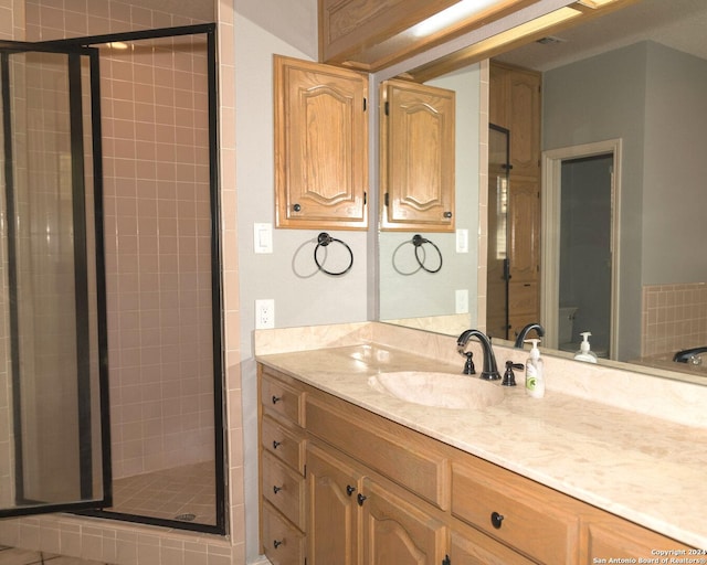 bathroom with vanity and a shower with door