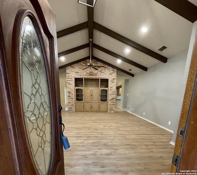 interior space featuring light wood-type flooring, vaulted ceiling with beams, built in features, and ceiling fan