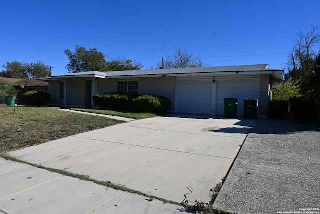 ranch-style house featuring a front yard and a garage