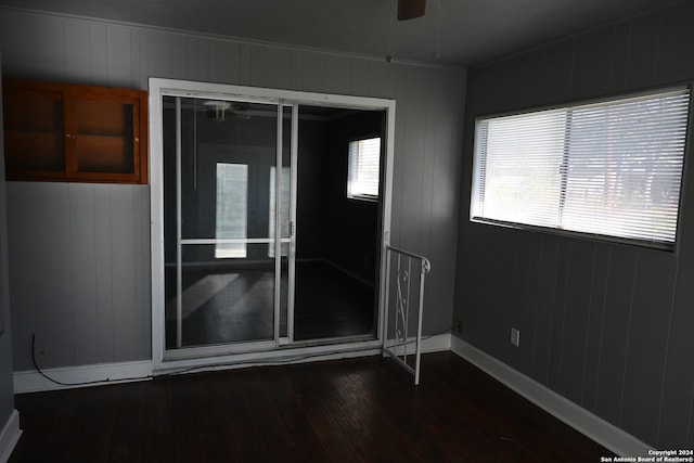 empty room featuring ceiling fan, crown molding, and dark hardwood / wood-style floors