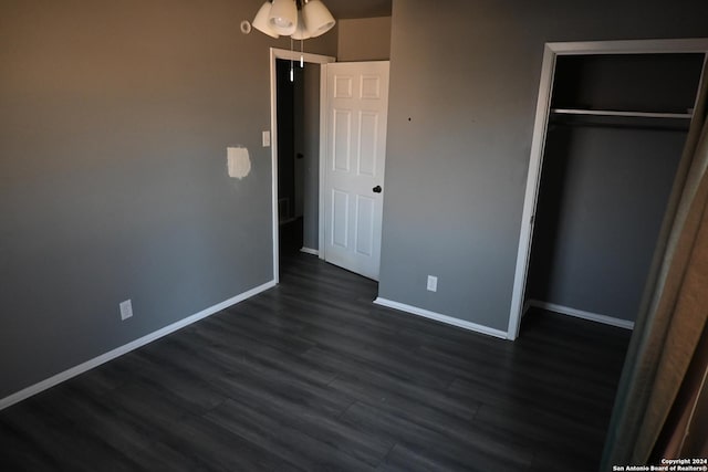 unfurnished bedroom featuring a closet and dark wood-type flooring