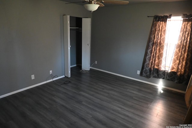 unfurnished bedroom with ceiling fan, dark wood-type flooring, and a closet