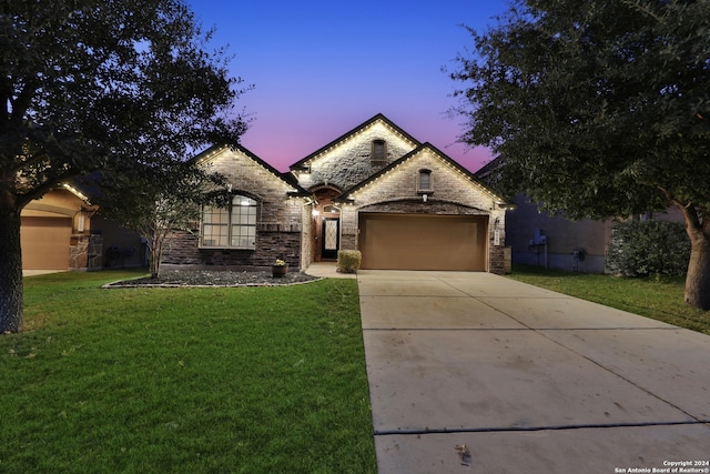 view of front of home with a lawn and a garage