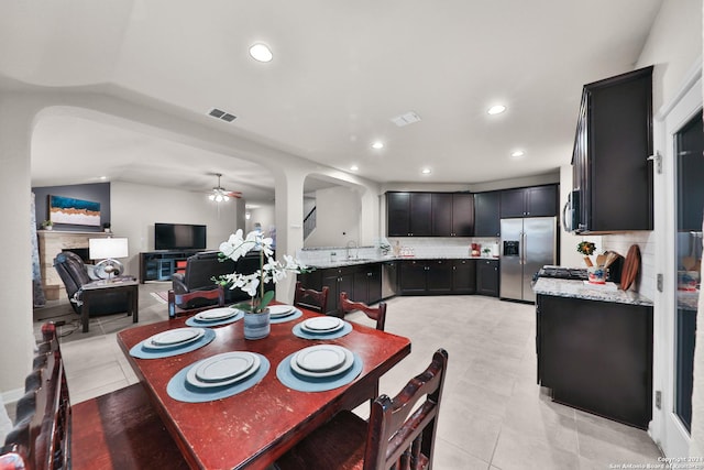 tiled dining area featuring ceiling fan and sink