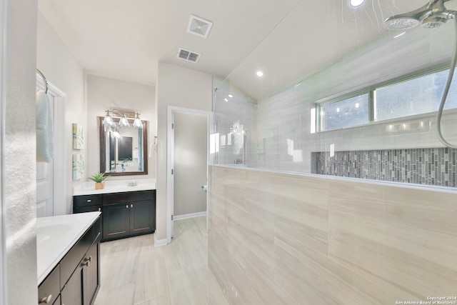 bathroom featuring a tile shower and vanity