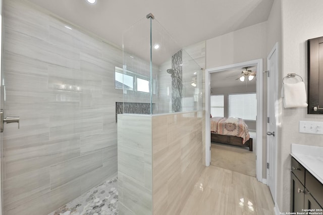 bathroom featuring tiled shower, a wealth of natural light, vanity, and ceiling fan