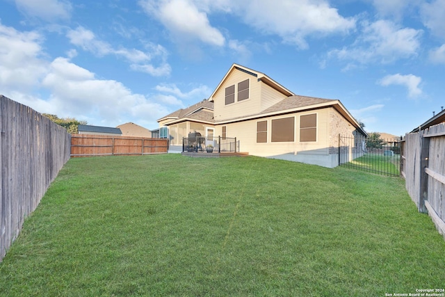 rear view of house featuring a lawn