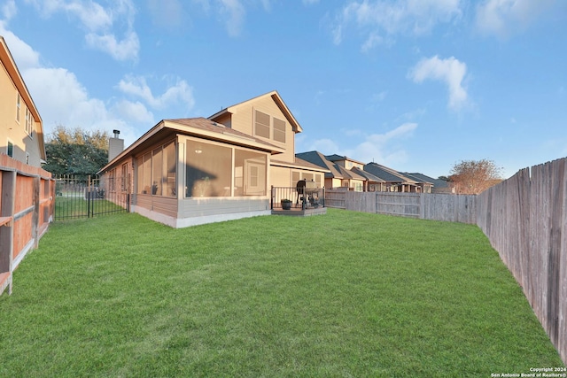 rear view of property with a lawn and a sunroom