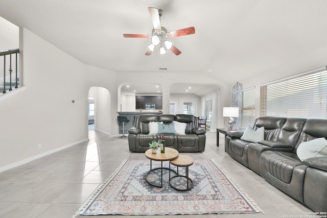 living room featuring light tile patterned floors, vaulted ceiling, and ceiling fan