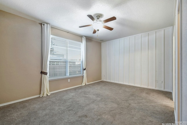 spare room featuring carpet, ceiling fan, and a textured ceiling