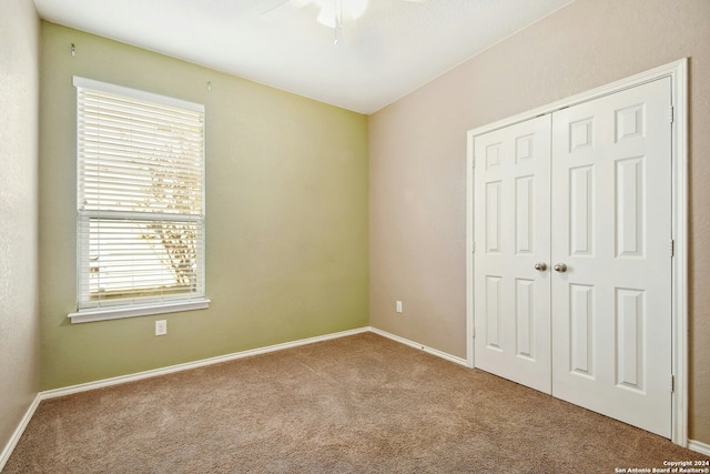 unfurnished bedroom featuring carpet, a closet, and ceiling fan