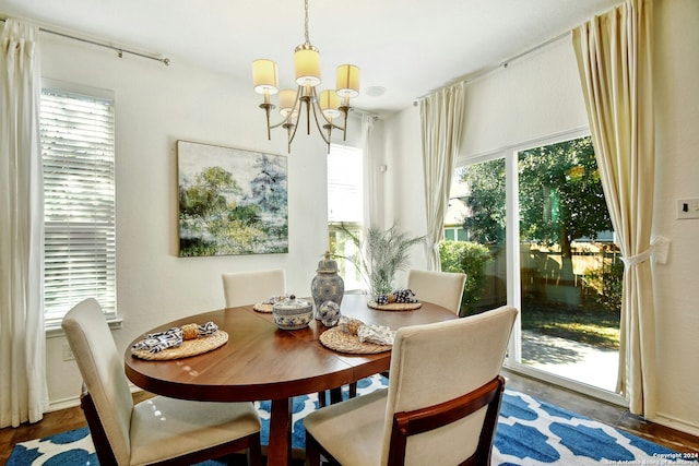 dining room featuring a wealth of natural light, dark wood-type flooring, and a notable chandelier