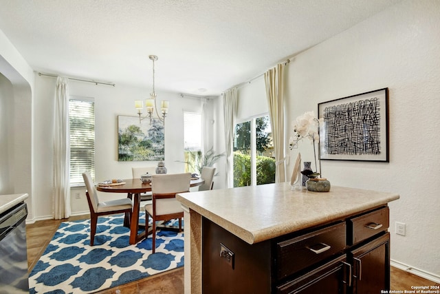 kitchen featuring pendant lighting, a center island, stainless steel dishwasher, and a wealth of natural light