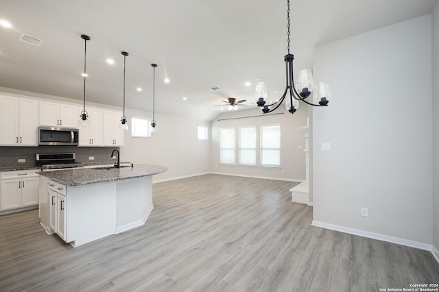 kitchen with ceiling fan, sink, stainless steel appliances, light hardwood / wood-style flooring, and a center island with sink