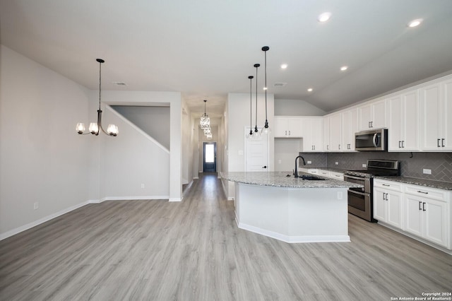 kitchen featuring white cabinets, stainless steel appliances, a center island with sink, and light hardwood / wood-style floors