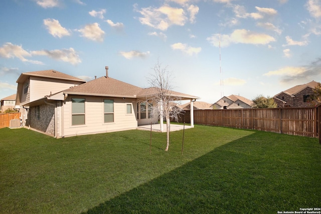 rear view of property with a lawn and a patio