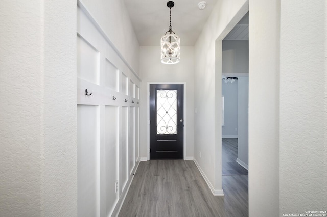 mudroom with an inviting chandelier and light wood-type flooring