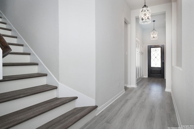 entryway with light wood-type flooring and a notable chandelier