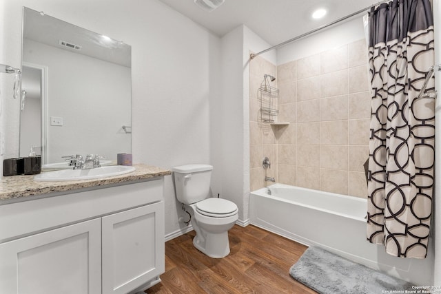 full bathroom featuring hardwood / wood-style floors, vanity, shower / tub combo, and toilet