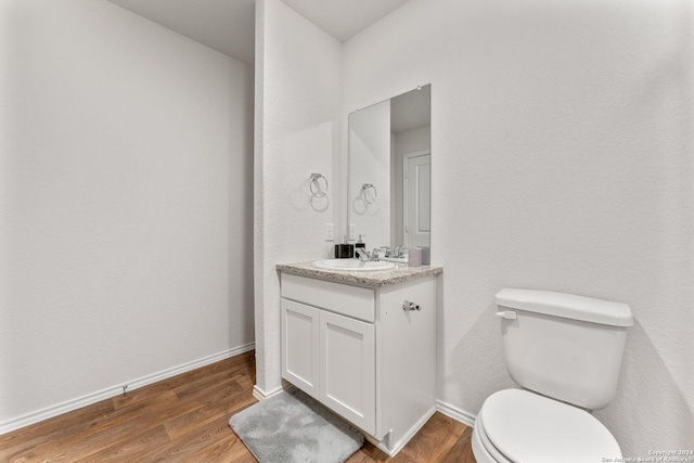 bathroom featuring hardwood / wood-style flooring, vanity, and toilet