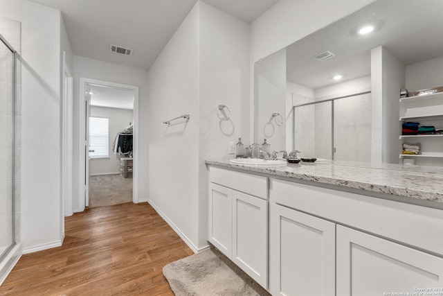 bathroom featuring hardwood / wood-style floors, vanity, and walk in shower