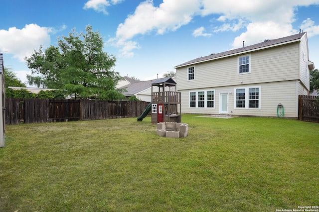 rear view of property with a lawn and a playground