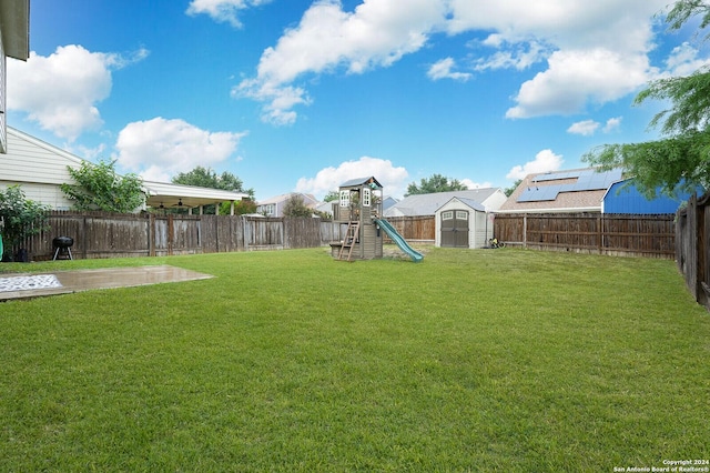 view of yard with a storage unit and a playground