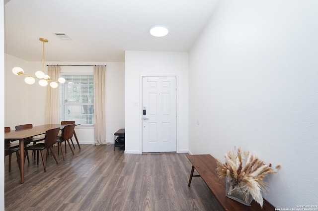 entrance foyer featuring an inviting chandelier and dark wood-type flooring