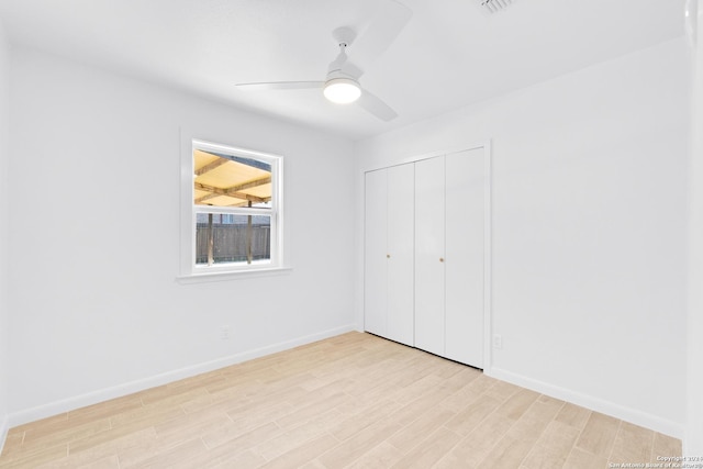 unfurnished bedroom with ceiling fan, a closet, and light wood-type flooring