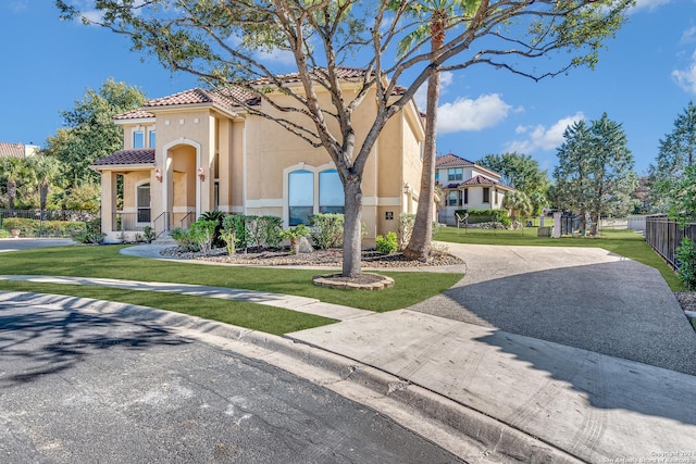 mediterranean / spanish-style house with a front yard