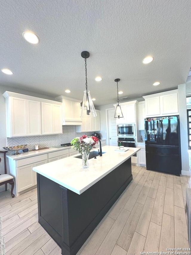 kitchen featuring white cabinets, stainless steel appliances, and light wood-type flooring