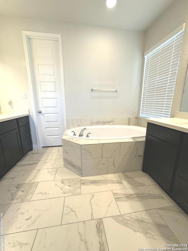 bathroom featuring vanity and a relaxing tiled tub