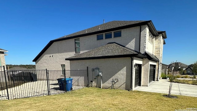 rear view of house with a garage and a yard