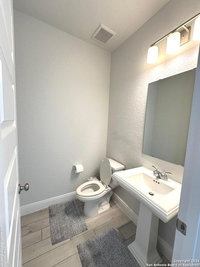 bathroom featuring hardwood / wood-style flooring and toilet