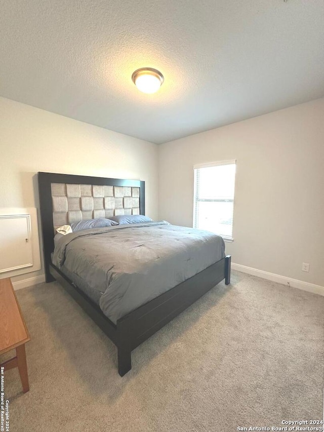 bedroom featuring carpet floors and a textured ceiling