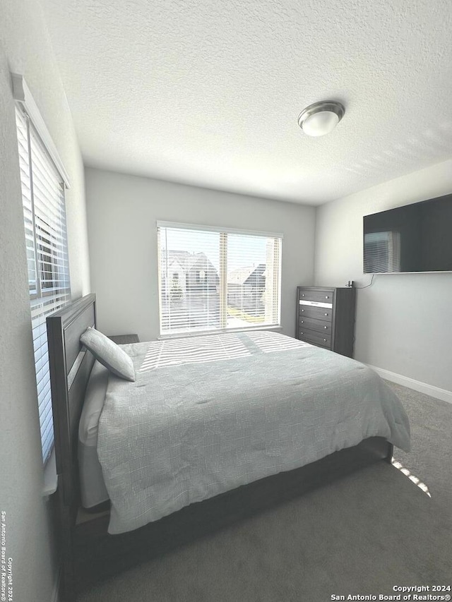 carpeted bedroom featuring a textured ceiling