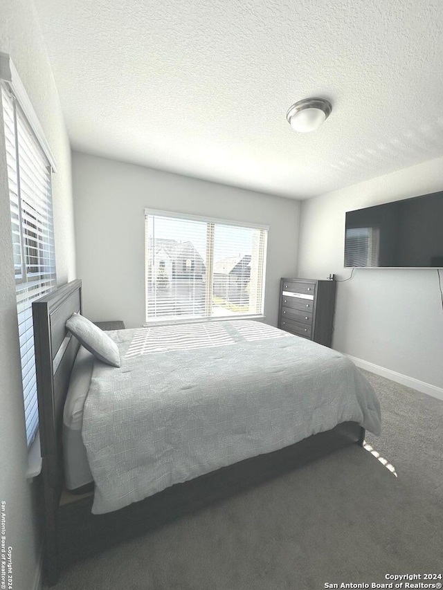 carpeted bedroom featuring a textured ceiling