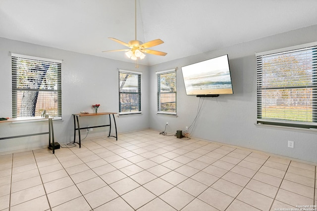 tiled spare room featuring ceiling fan and a healthy amount of sunlight