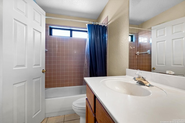 full bathroom featuring tile patterned floors, vanity, a textured ceiling, shower / bath combo with shower curtain, and toilet