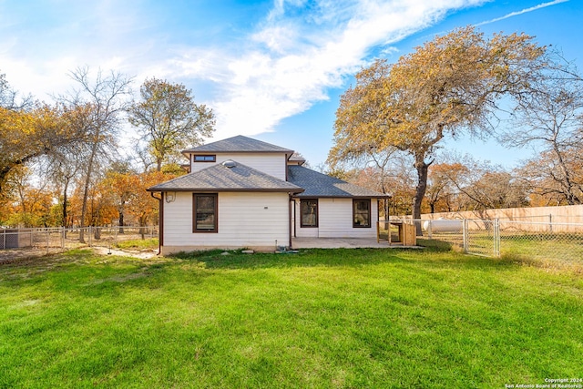 rear view of house with a yard and a patio area